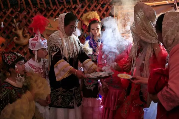 哈萨克族的婚礼习俗--新娘​经由伴娘陪同进入公婆毡房，向公婆等行礼，​并举行“拜火”仪式。