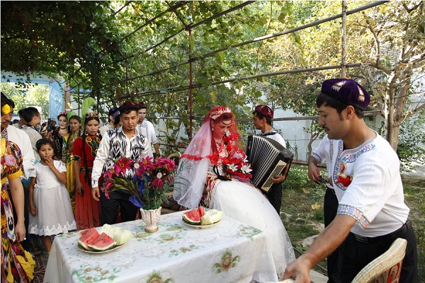 独具风情的维吾尔族婚礼习俗--第二天是婚礼的高潮，在男方家举行揭盖头仪式。这一天同样是在欢宴中度过的。女方家的亲戚到男方家去，男方家要热情款待。